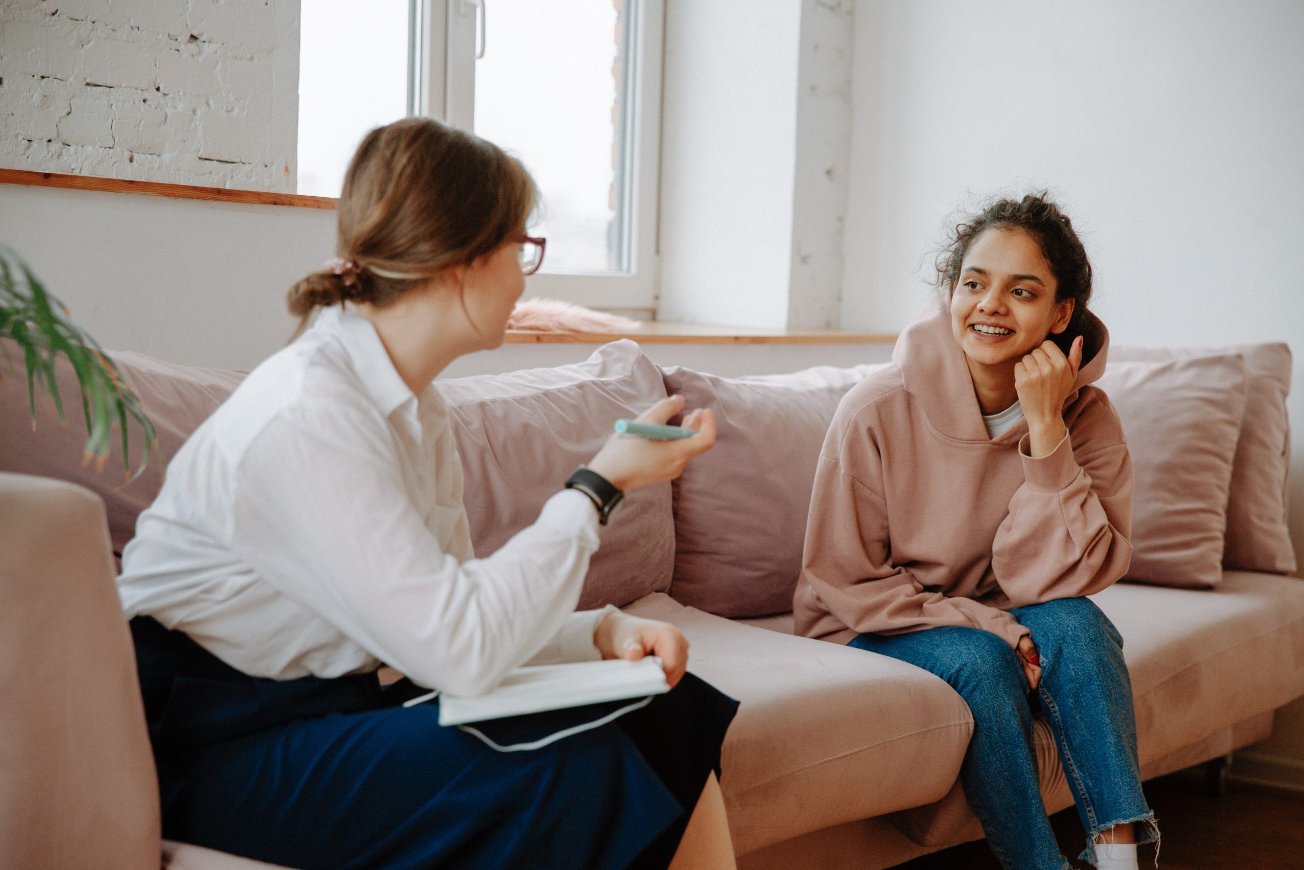  A therapist is sitting on a couch, talking to a patient.